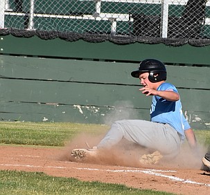 Ty Nelson from the Diamond Ducks slides safely onto home plate to score a run during the first game against the Tigers Tuesday.