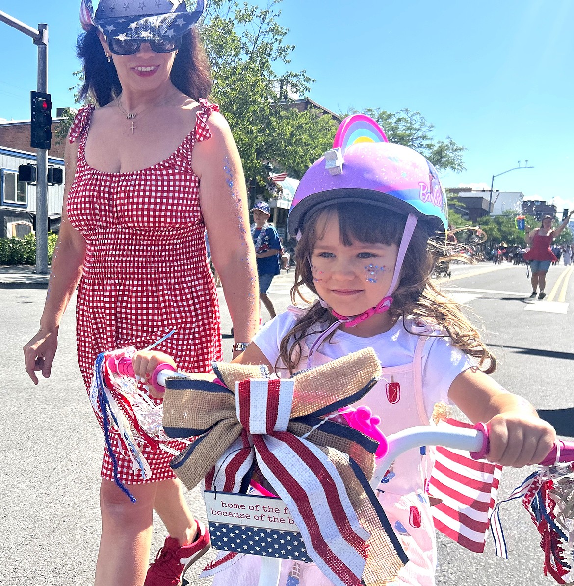 Anne Mitchell walks alongside daughter Vivienne during Coeur d'Alene's Kiddie Parade on Thursday.