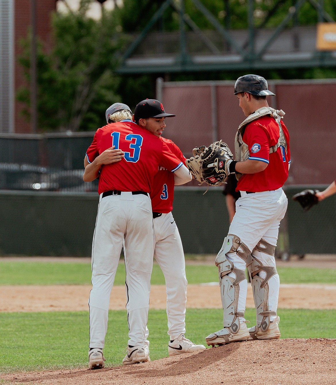 Quade Gonzalez hugs his teammate Aiden Garza as Team Rainier gathers on the mound to compliment Garza’s pitching during All-State.