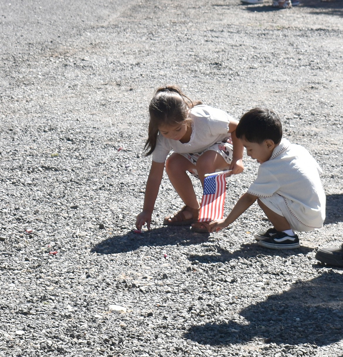 Amaya Cruz, 3 (left) and Mateo Cruz, 2, gather candy at the George Fourth of July Parade Saturday.