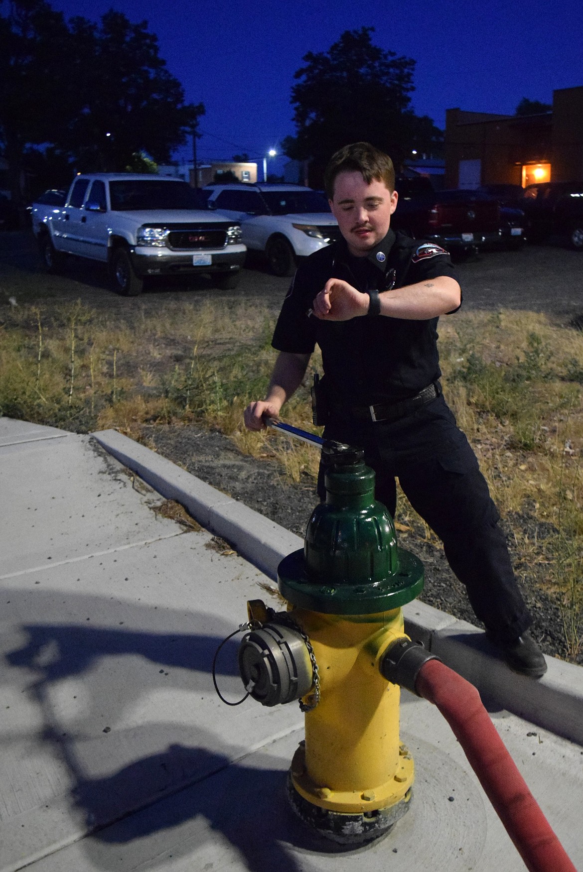 Grant County Fire District 7 volunteer Evan Bolyard works on filling a brush truck as another fire comes in on the scanner on the Fourth of July.