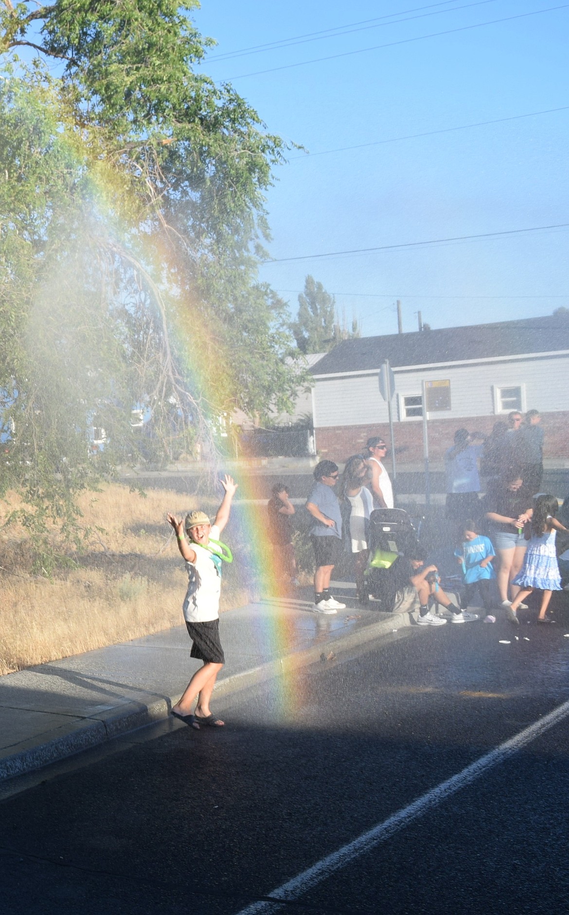 Fourth of July parade attendees enjoy getting sprayed by brush trucks prior to the engines leaving the parade due to various fire calls.