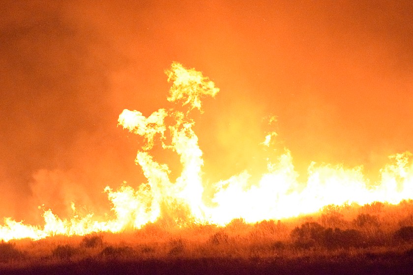 Flames fill the night sky across Grant County as firefighters work to contain over 100 fires across the terrain.