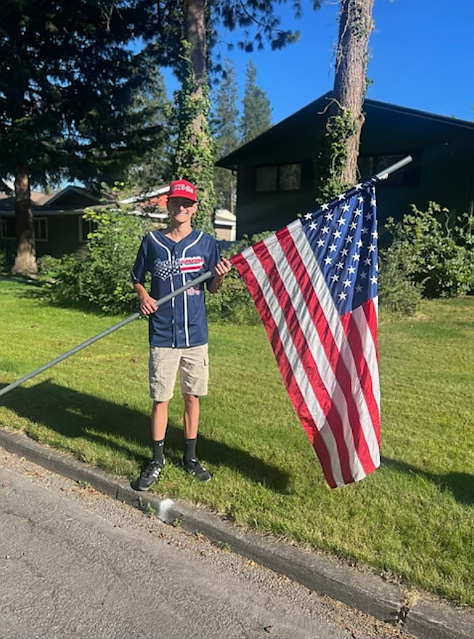 Courtesy photo
Cameron Biery of the Coeur d'Alene Lumbermen 14U team poses with a flag on the Fourth of July. The Coeur d'Alene Lumbermen AA team and 14U team partnered with the Kiwanis Club in lining the streets of Coeur d'Alene with American flags on the Fourth of July. More than 250 flags were placed along nine routes throughout the city; the Lums players returned that evening to pick them up.