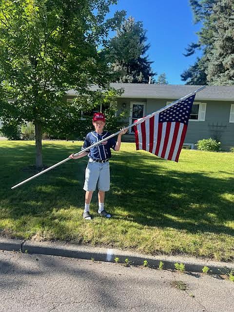 Courtesy photo
Sam Horner of the Coeur d'Alene Lumbermen 14U team poses with a flag on the Fourth of July. The Coeur d'Alene Lumbermen AA team and 14U team partnered with the Kiwanis Club in lining the streets of Coeur d'Alene with American flags on the Fourth of July. More than 250 flags were placed along nine routes throughout the city; the Lums players returned that evening to pick them up.