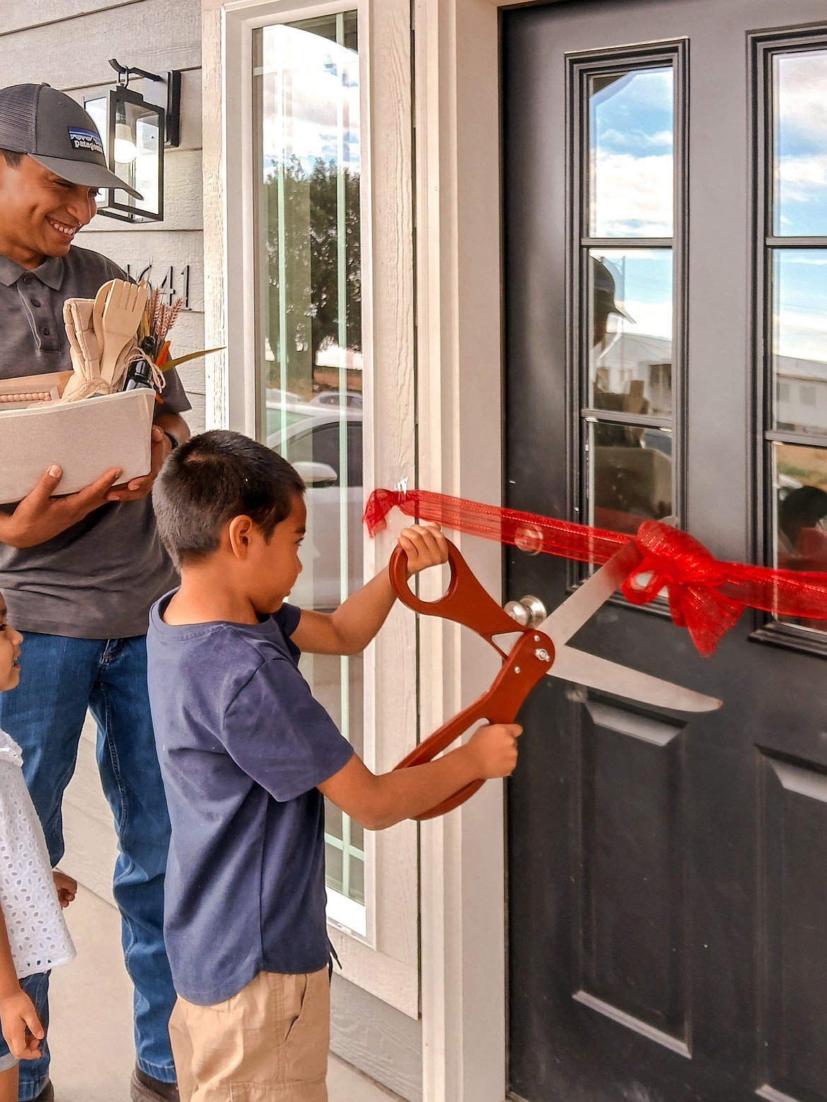 A child cuts the ribbon on a Catholic Charities Housing Services home.