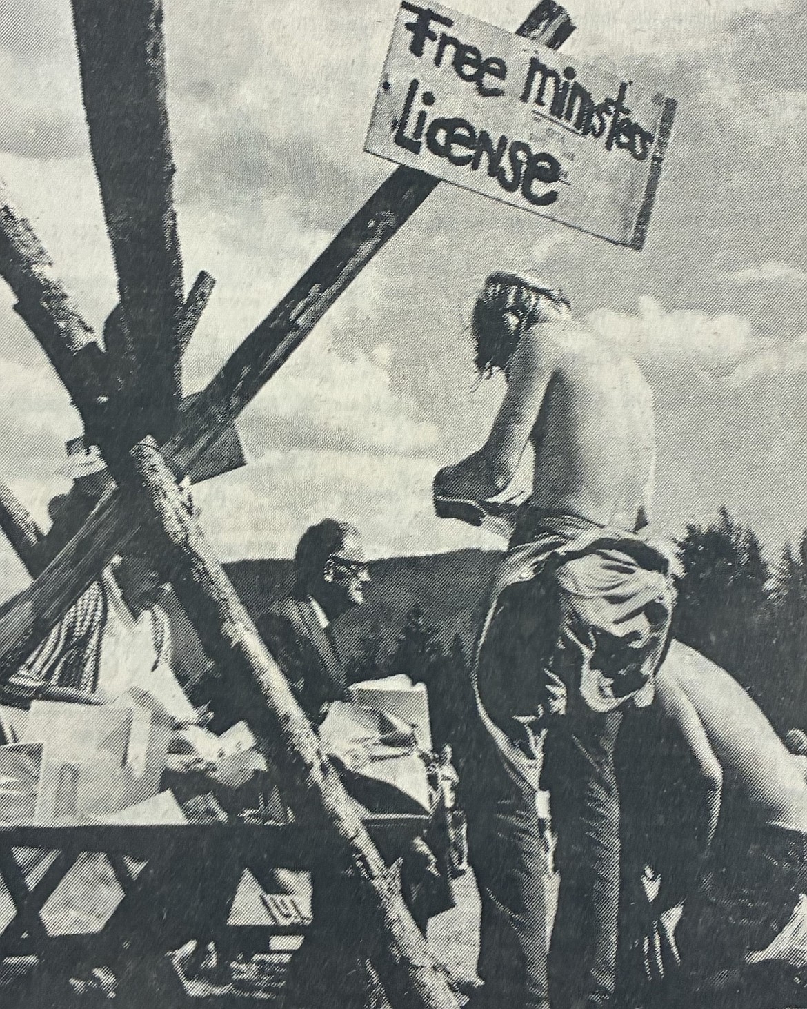 An attendee (standing) signs the roster of ministers during the 1971 Universal Life Church Picnic at Farragut State Park. Church founder Kirby J. Hensley, of Modesto, Calif., (second from left) is shown in the background.