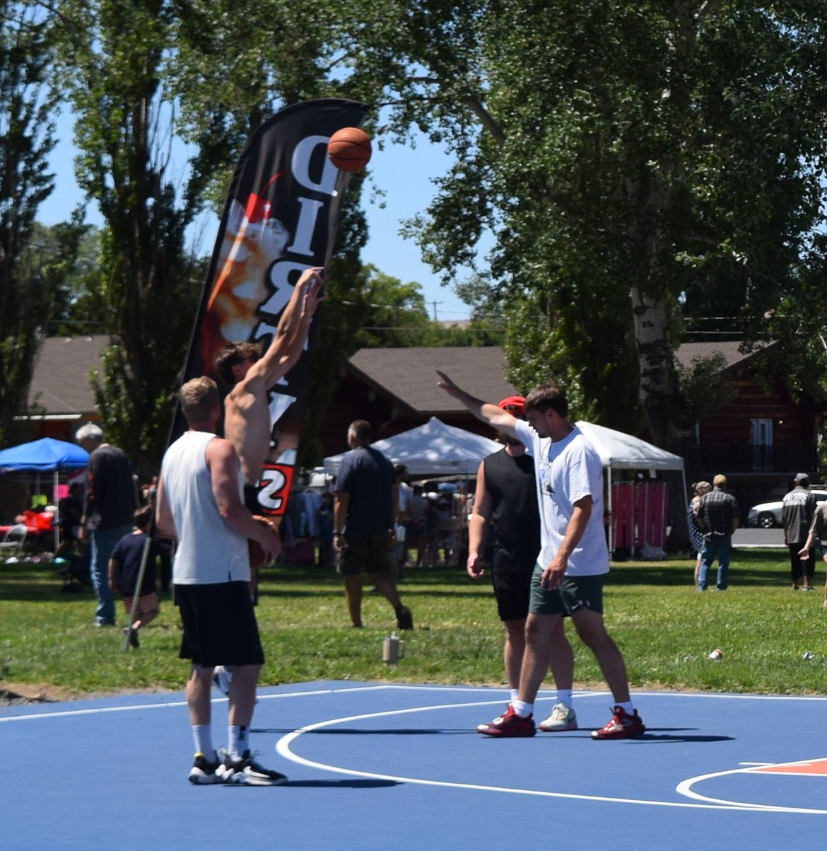 A player shoots for three under pressure from his opponents during the Soaring Eagles basketball tournament Saturday.