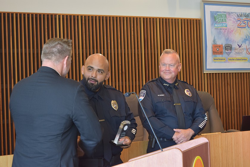 Detective Edgar Salazar (middle) receives the Eastern District of Washington’s 2026 Hometown Hero award from First Assistant U.S. Attorney Pete Serrano (left). Moses Lake Police Dept. Chief Dave Sands (right) grins as he accepts it.