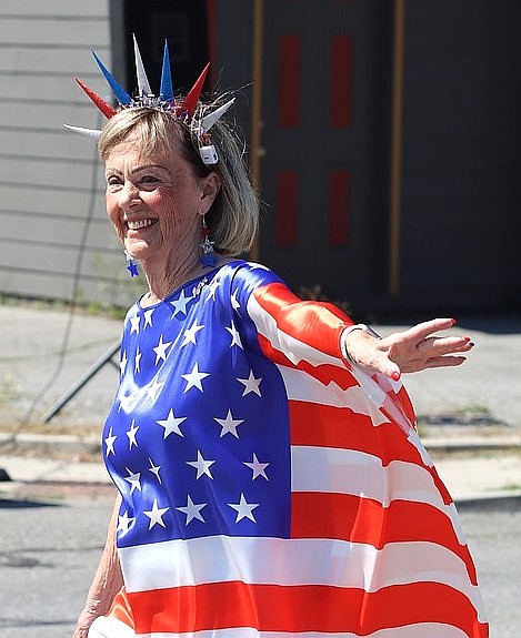 Carolyn Strauch walks with her arm out so her American flag dress can blow in the wind.