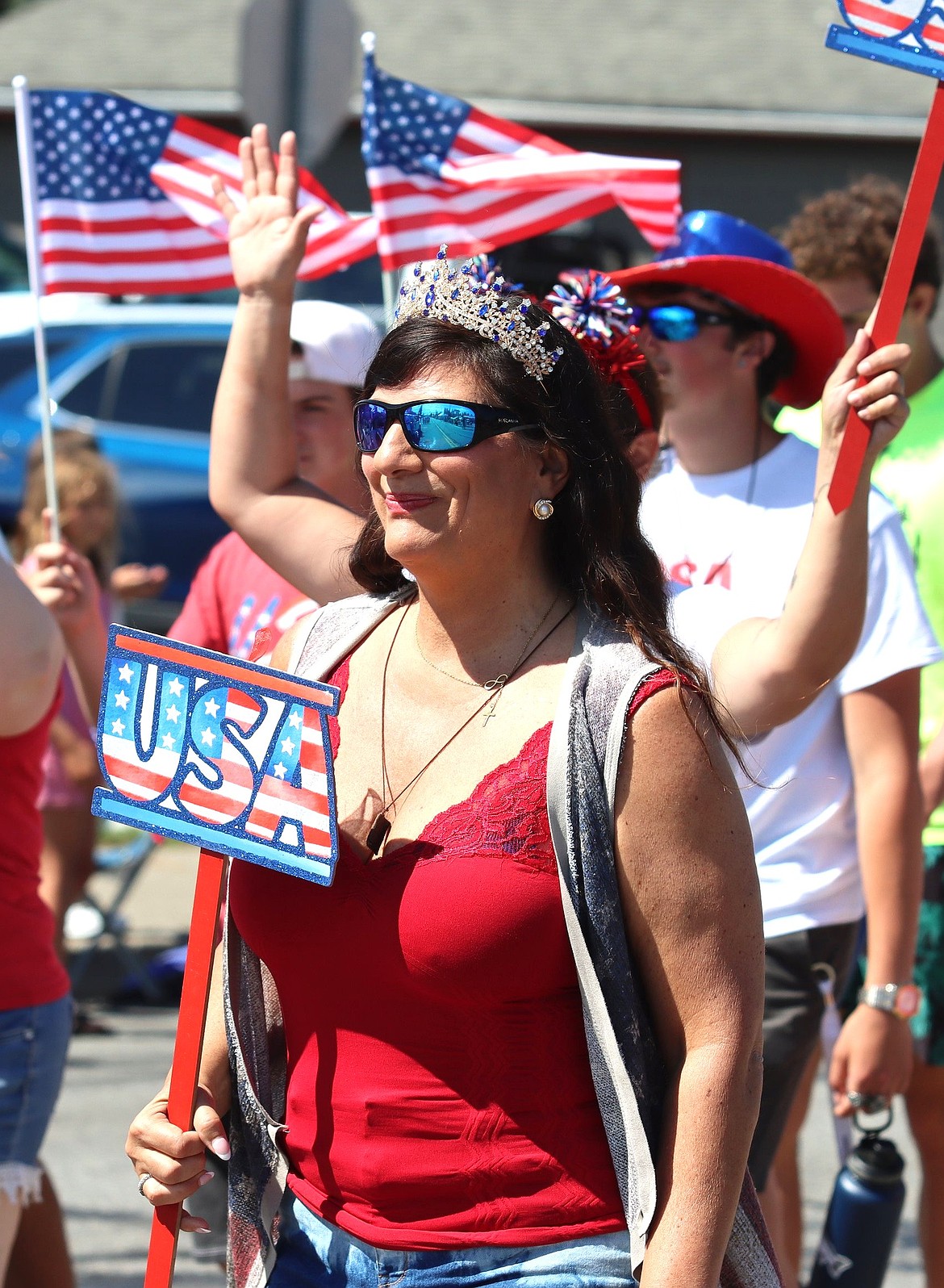 Mary Pettit waves a USA sign in celebration of America250.