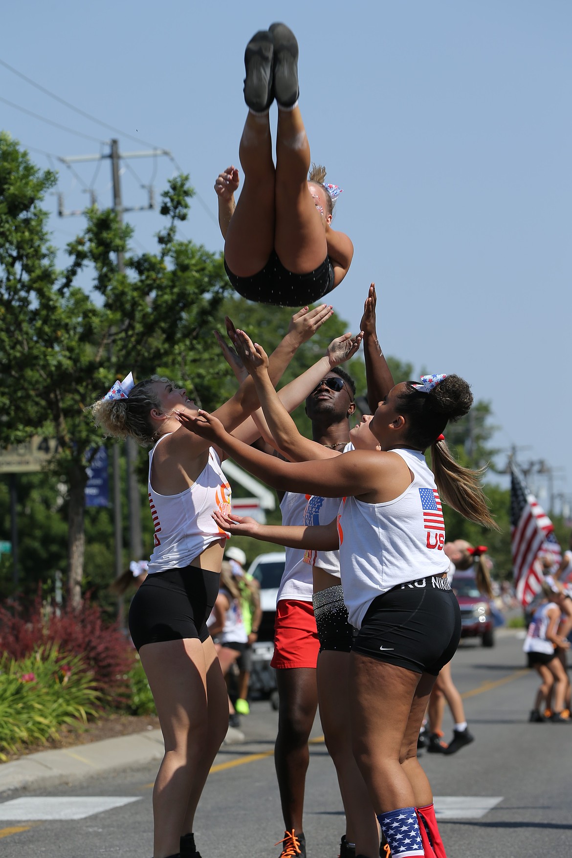 Athletes with Spotlight Studios prepare to catch a teammate after a jump along the Hayden Days parade route.