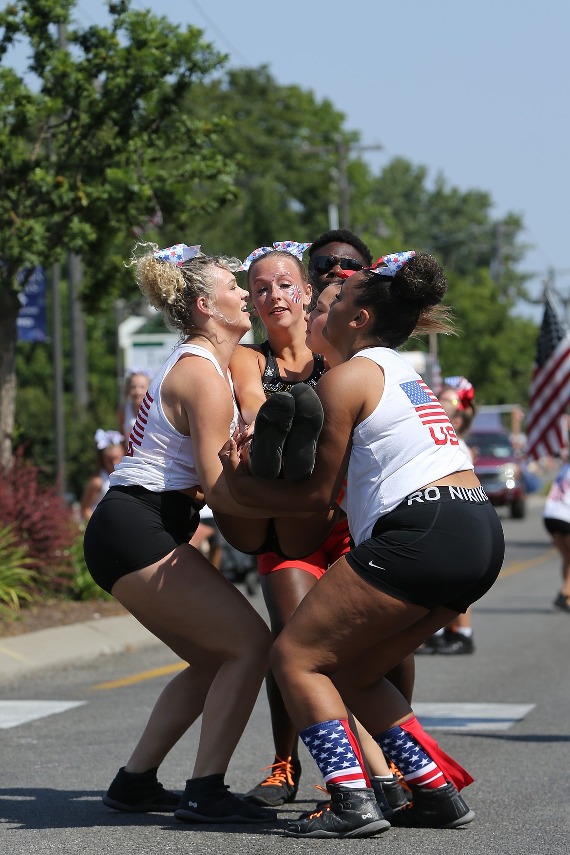 An athlete with Athletes with Spotlight Studios lands safely in the arms of her teammates.
