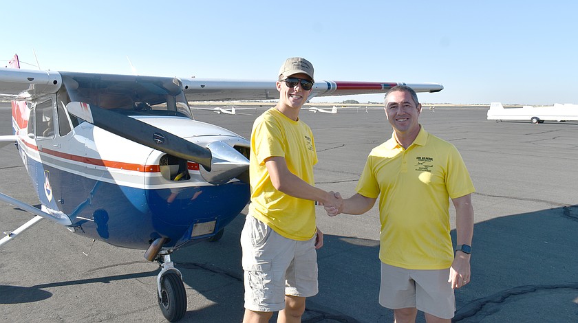 Civil Air Patrol Cadet Ethan Birkhead, fresh from his first solo flight, shakes hands with his instructor, Maj. James Davis, Thursday morning at the Civil Air Patrol’s Desert Eagle Flight Academy in Ephrata.