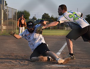 An adult softballer slides into home plate while trying to avoid the tag earlier this season.