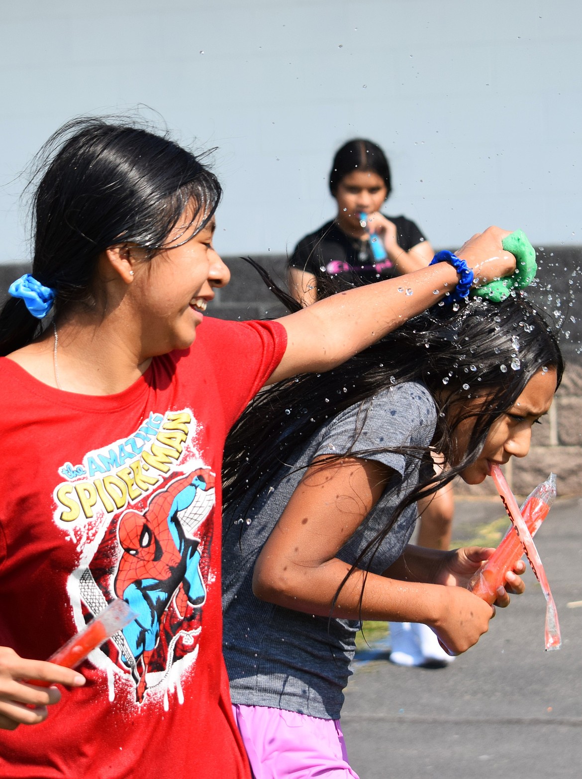 A Warden Middle School student armed with a sponge attacks one of their friends with water during the field day Thursday.