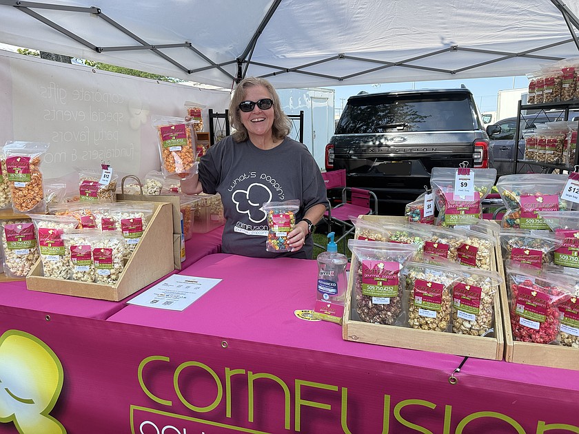 Debbie Doran-Martinez, proprietor of Cornfusion gourmet popcorn, offers a variety of flavored popcorn at the Moses Lake Farmers Market Saturday.