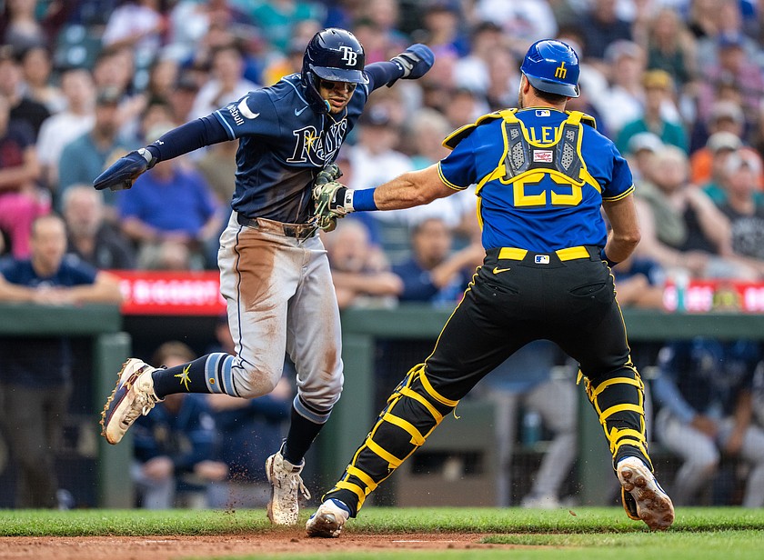 Seattle Mariners catcher Cal Raleigh (right) tags out Tampa Bay Rays' Victor Mesa Jr., left, during the fifth inning of a baseball game, Friday, Aug. 7 in Seattle.