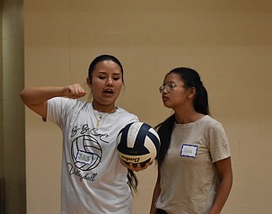 Jah Chong from the Vikings explains proper serving form to a young athlete during Wednesday’s training camp.