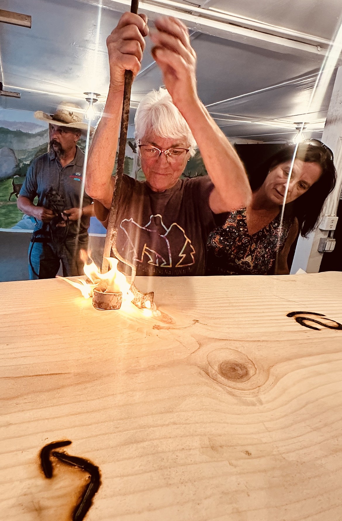 Donna Boekel brands a bar top that will be displayed during the North Idaho State Fair.