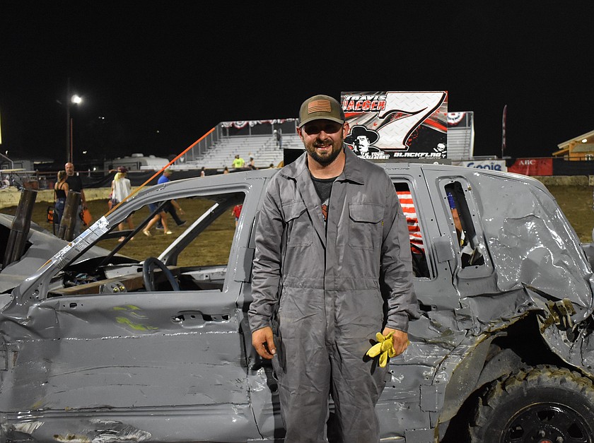 Following an exciting demo derby, Travis Jaeger stands proud next to his vehicle as the last car standing to earn a first-place finish.