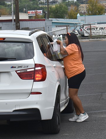 A Solarity Credit Union employee accepts a donation for the Moses Lake Food Bank at the credit union’s shredding event Saturday.