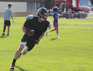 Treyson Kast hauls in a pass from Max Grindy (not pictured) during the Almira/Coulee-Hartline Warriors practice.