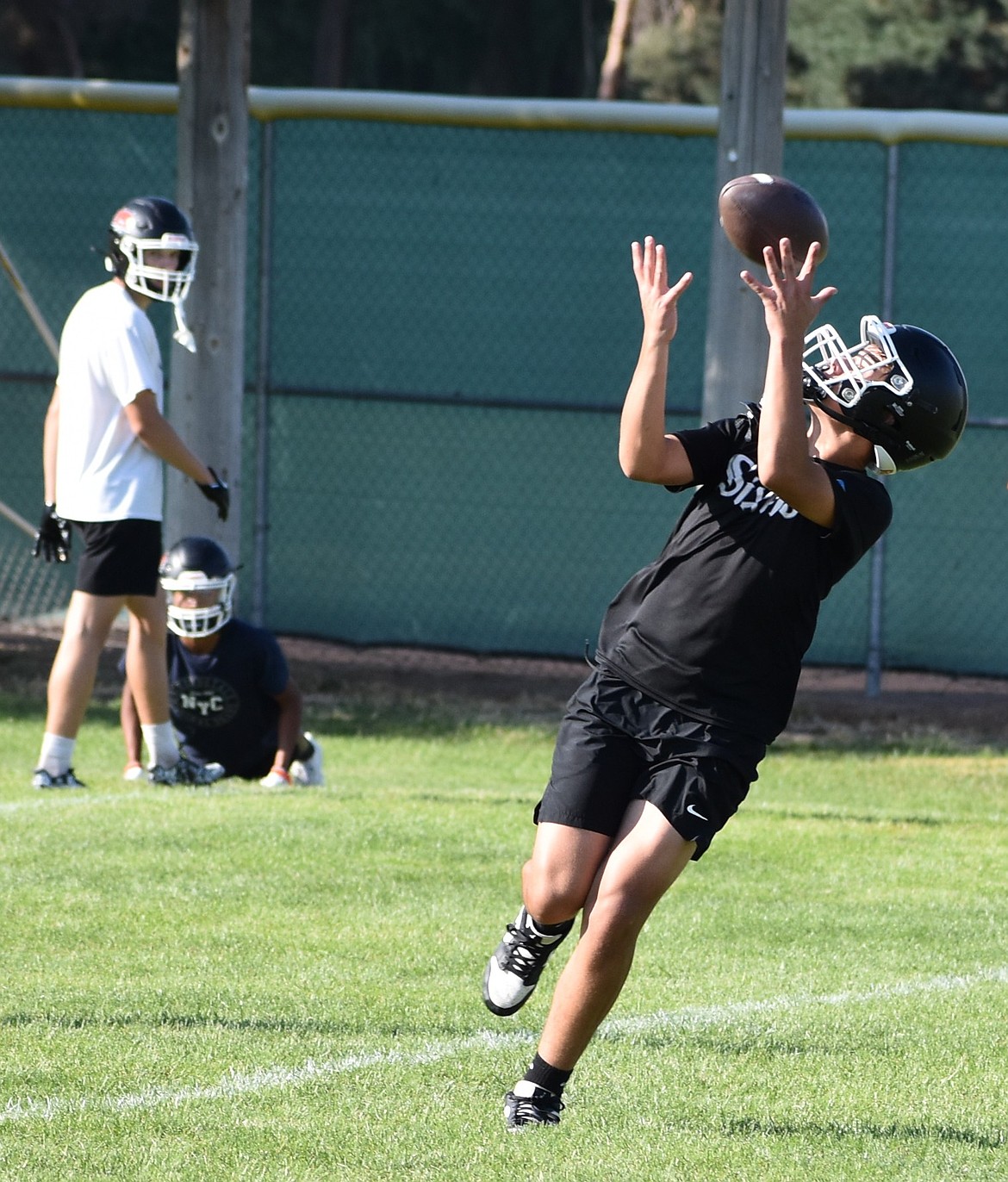 Cannon DeLong from the Tigers receivers makes a catch at practice as the team split off for individual skills training.