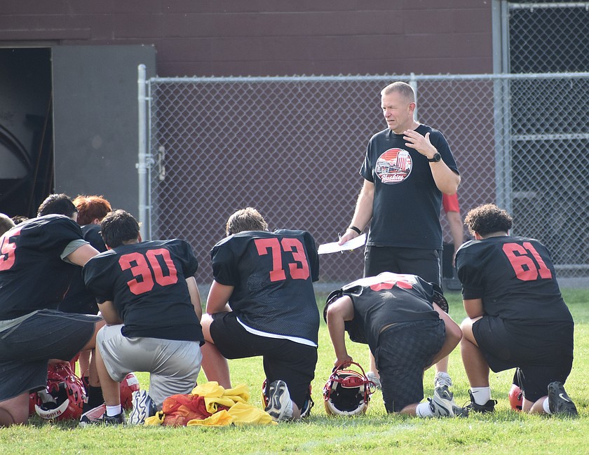 The Othello Huskies gather around their new head coach Jerome Learman during an early season practice.
