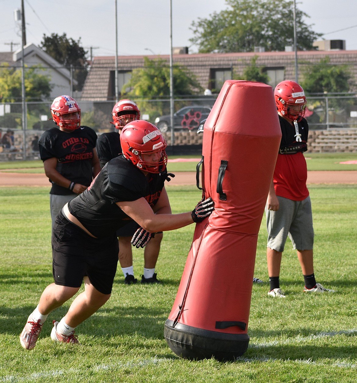Elliot Mitchell from Othello slams into a tackle dummy during summer practice as they prepare for the fall season.