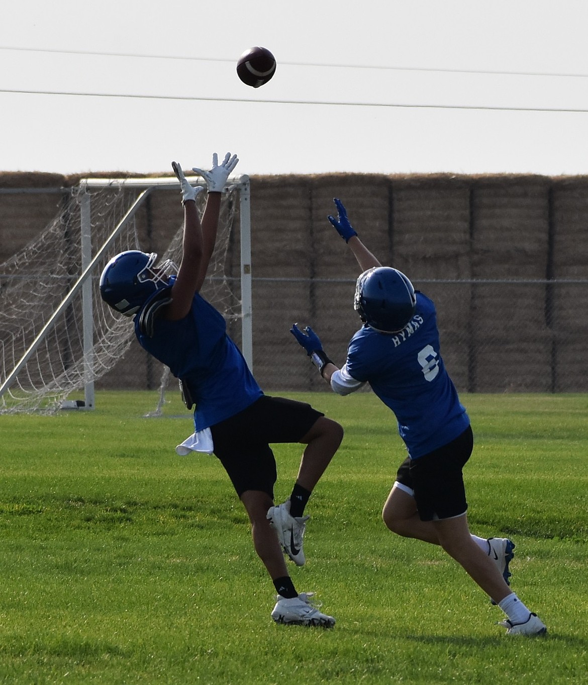 Eli Reyes works to complete a catch while his defending teammate Emmett Hymus works to stop the play in early season practice.