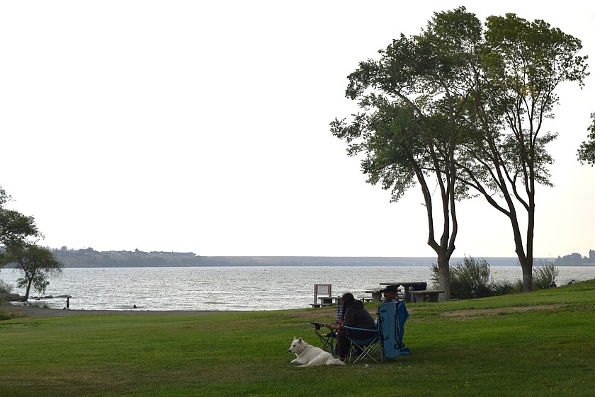 A dog and its owner relax at Connelly Park Saturday, the first day of its opening after being closed for the summer for storm cleanup and repairs. The Vintage Test & Tune event was held as well at the park over the weekend. Rain and wind picked up Saturday shutting down the event; however, the vintage speed boaters were back on the lake Sunday to gorgeous weather.