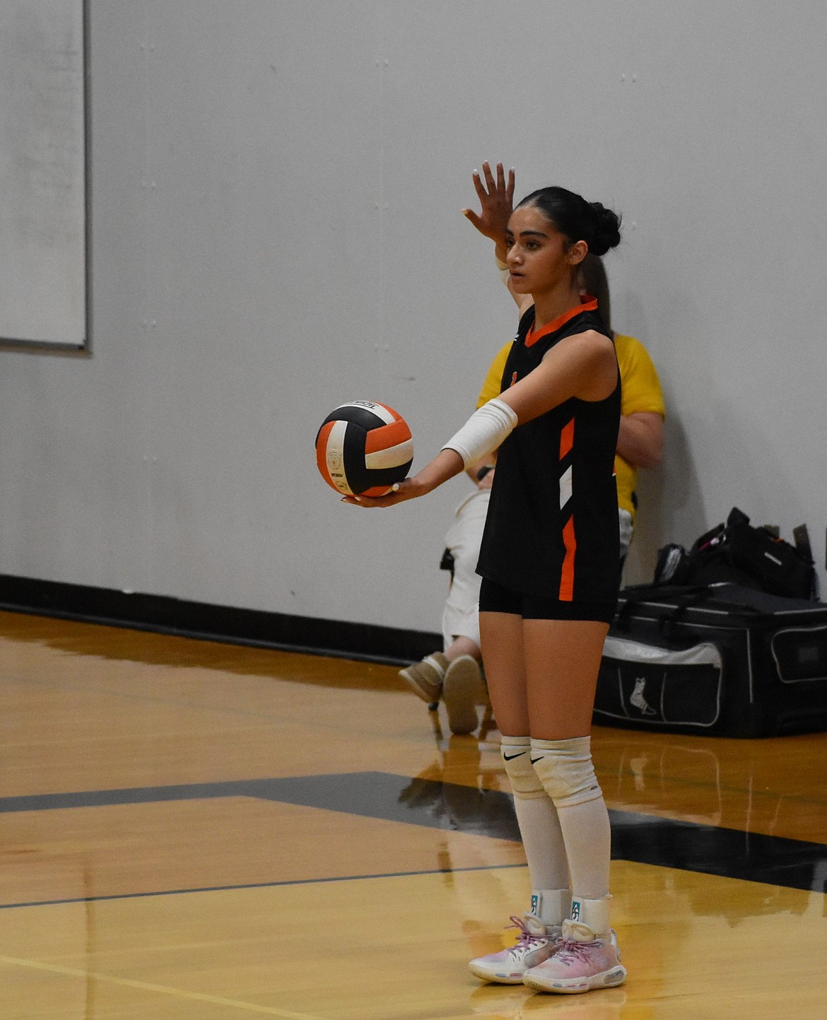 Navi Kaur, a junior from EHS, prepares to serve against Omak Tuesday evening during the season opener.