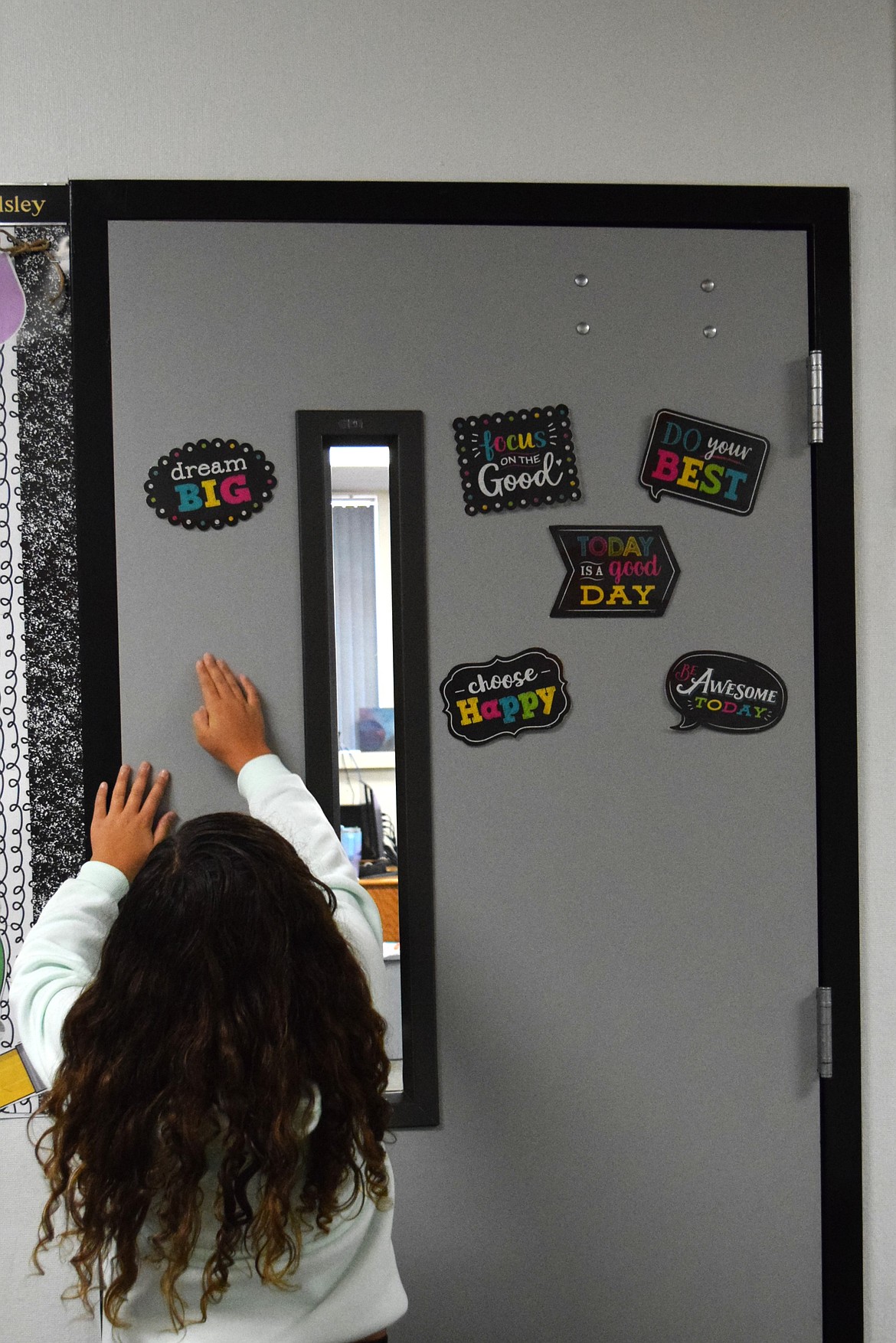 An Ephrata Parkway Intermediate student works on decorating her teacher's door with motivational messages on the first day of school.