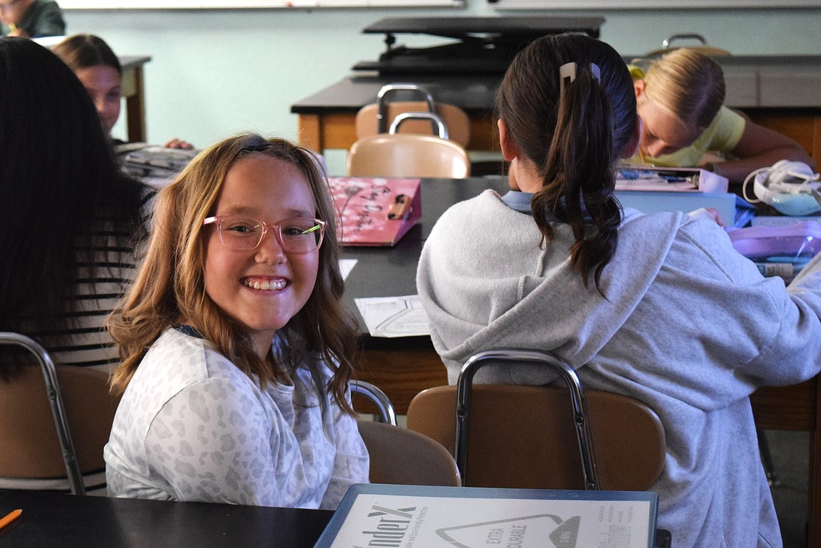 Students in a science class at Parkway Intermediate School work on filling out paper beakers with information about themselves during their first day back at school Thursday.