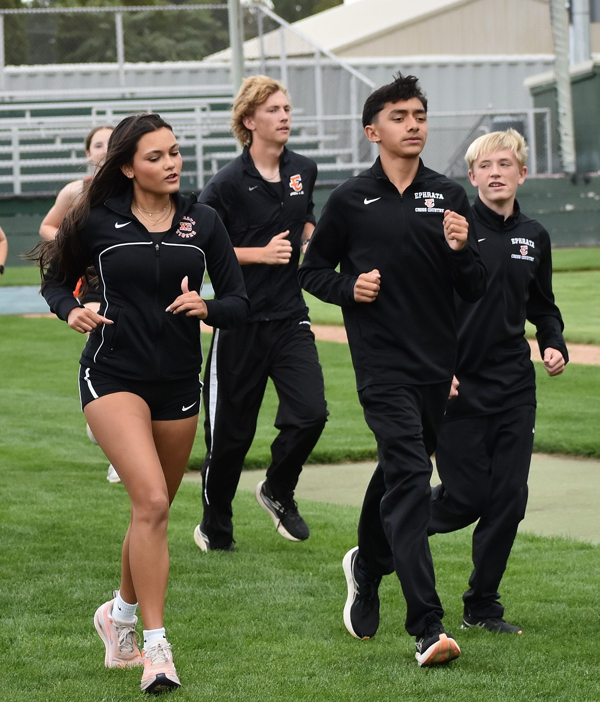 Hannah Malone, left, jogs alongside her fellow Tigers during a warmup at practice early in the fall.