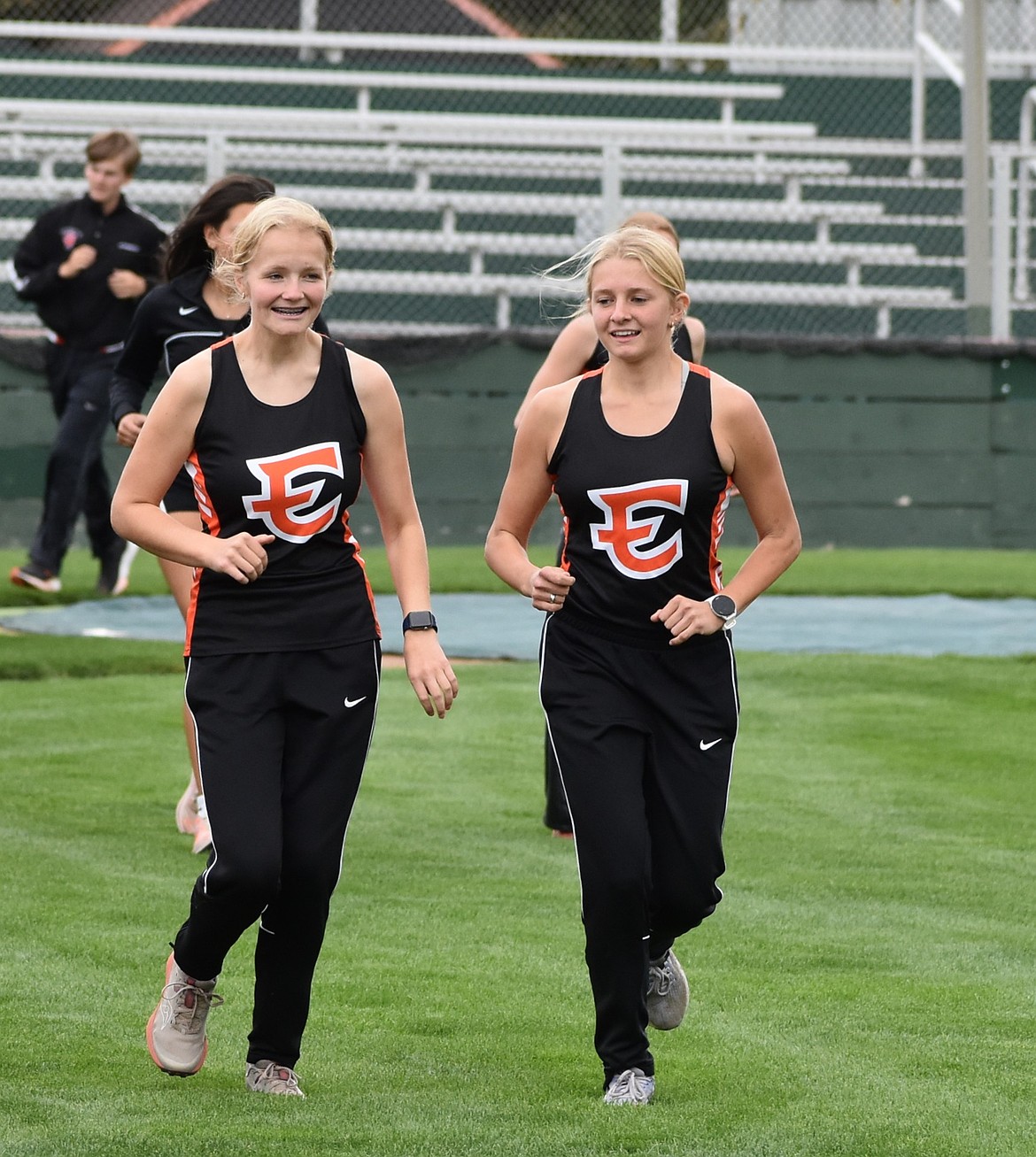 Two girls from the Tigers jog side by side in a warmup at practice early in the season.