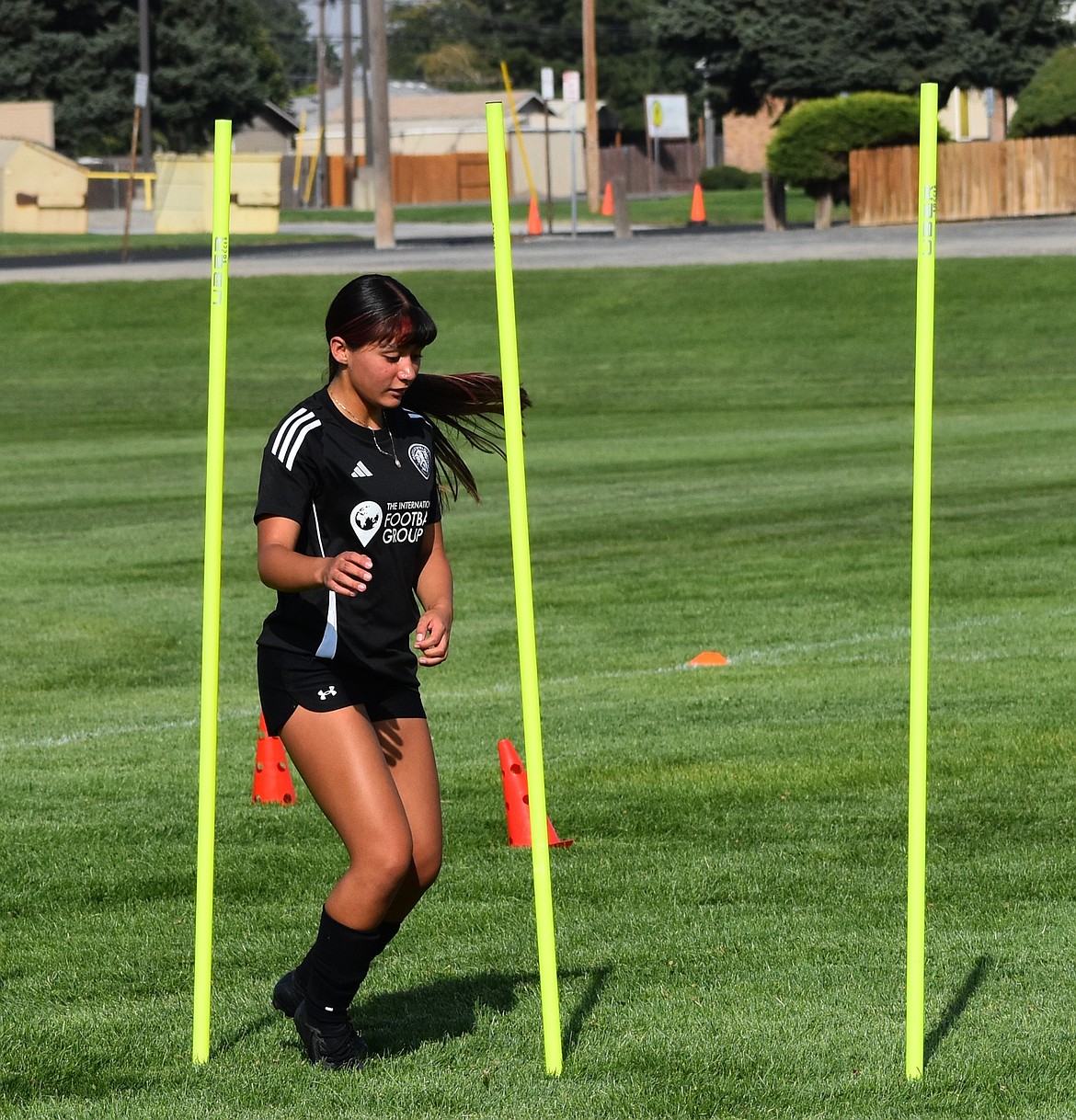 Elizabeth Garcia from the Huskies weaves around the sticks during an early-season workout in practice.