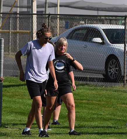 Warden senior LJ Beavers walks alongside the cross-country head coach Karla Banks as they discuss the next part of the afternoon practice.