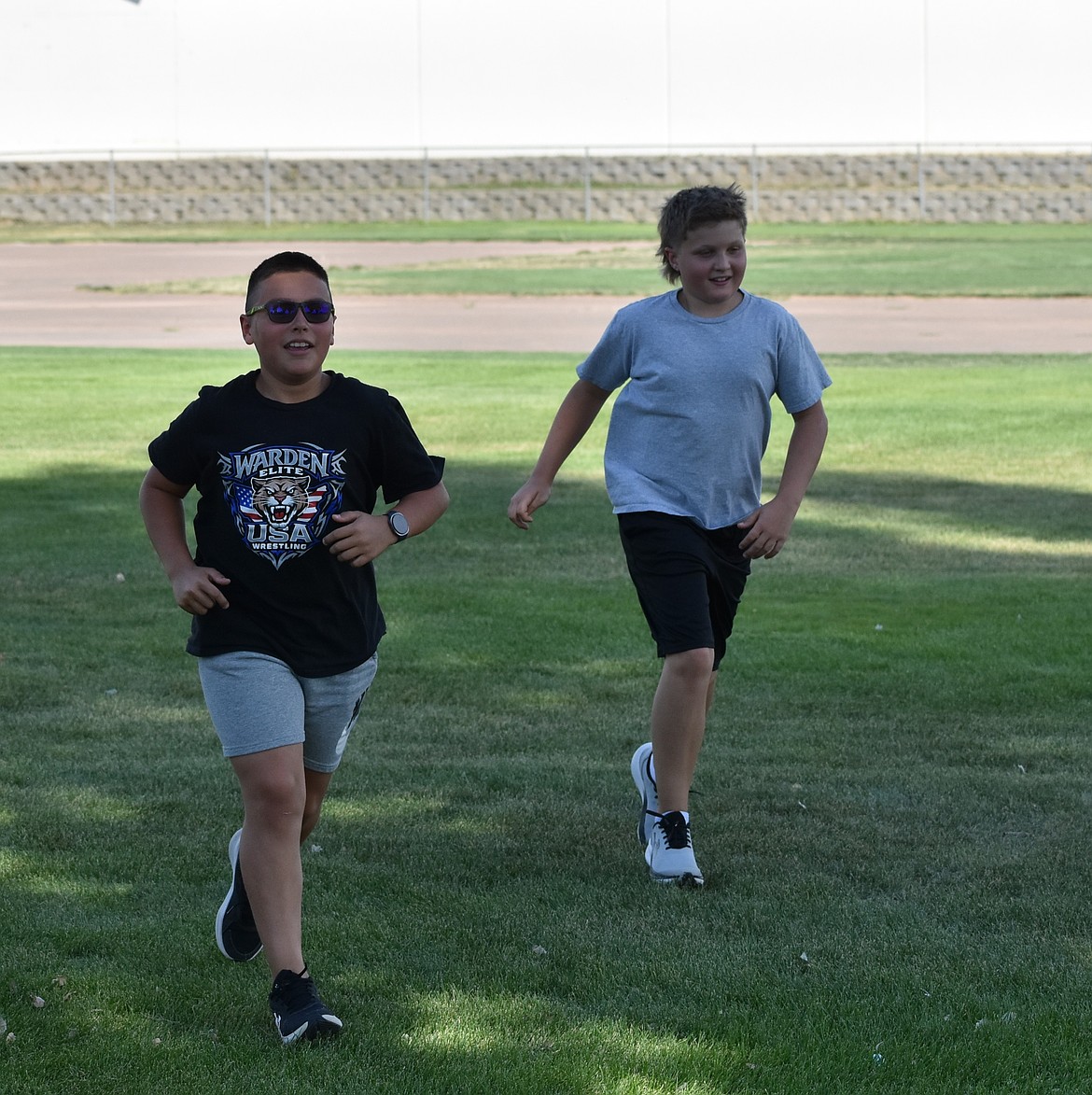 Two middle schoolers on the Cougars cross country team run side by side at practice early in the season.