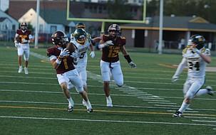 The Mavs' Grady Green (1) hauls in a deep pass catch over the middle from Nolan Decubber before taking it in for a touchdown against the Richland Bombers on Friday.