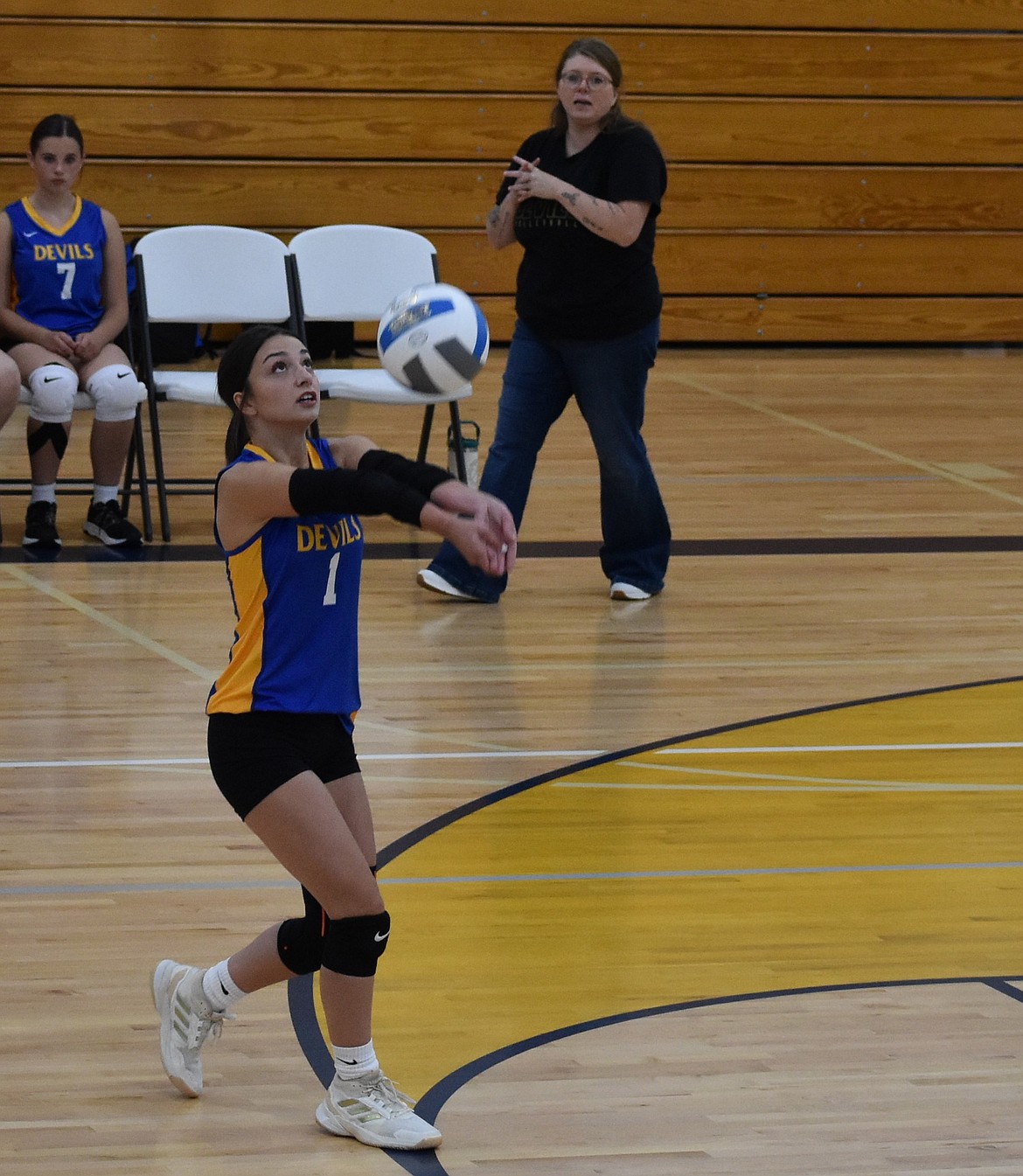 Cheyanne Dailey from the Devils bumps up the ball for one of her teammates to spike over the net against the Lions.