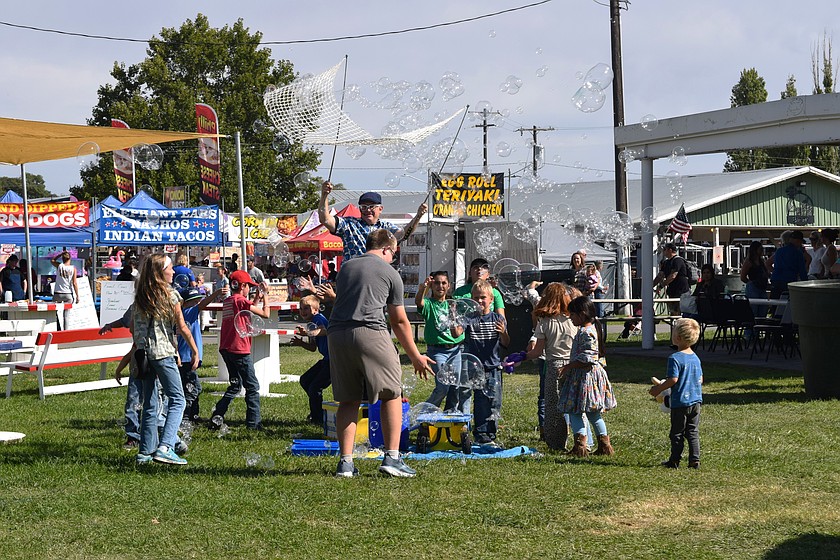 The Bubbler delights children with a stream of giant, shimmering bubbles at the Othello Fair on Thursday.