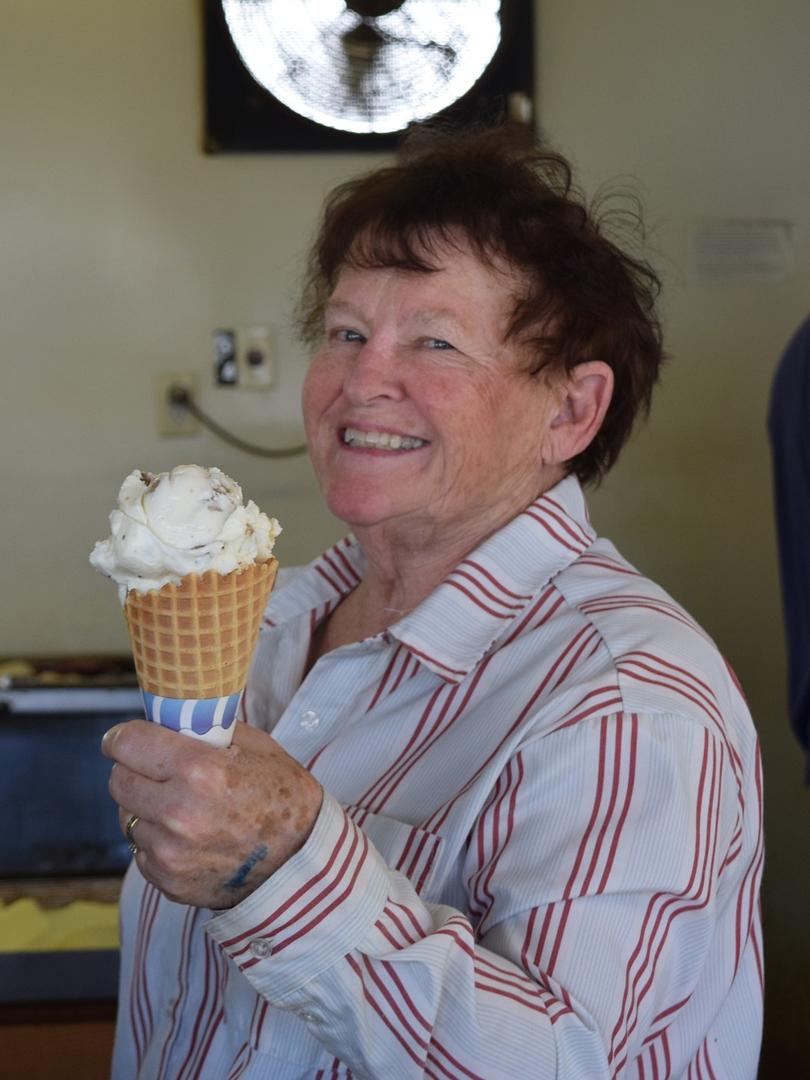 A volunteer presents a cookie dough ice cream cone as a customer arrives to claim the sweet treat at the Elephant Ear Booth during the Othello Fair on Thursday.