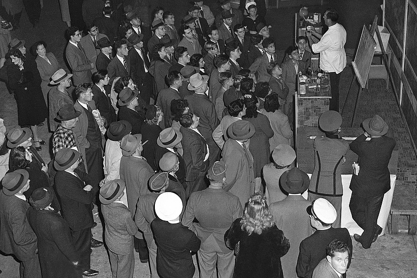 A man sells a tonic claiming to be good for any of several ailments while a crowd listens on 50th Street near Broadway in New York, on Dec. 1, 1944. (AP Photo/TR)