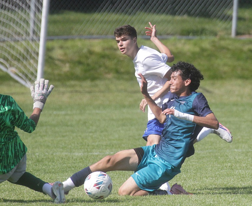 MARK NELKE/Press
Coeur d'Alene junior Asier Pacho Rodriguez (5) slides a shot under Lake City sophomore Leo Rubio (4) and onrushing Lake City keeper Sebastian Guitron for a goal in the first half Saturday at the Irma Anderl Soccer Complex at Lake City High.
