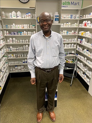 The late Lateef Olaniyan stands in Southgate Pharmacy, which he opened in Moses Lake in 2010. His sons would like to thank the community for its support over the years.