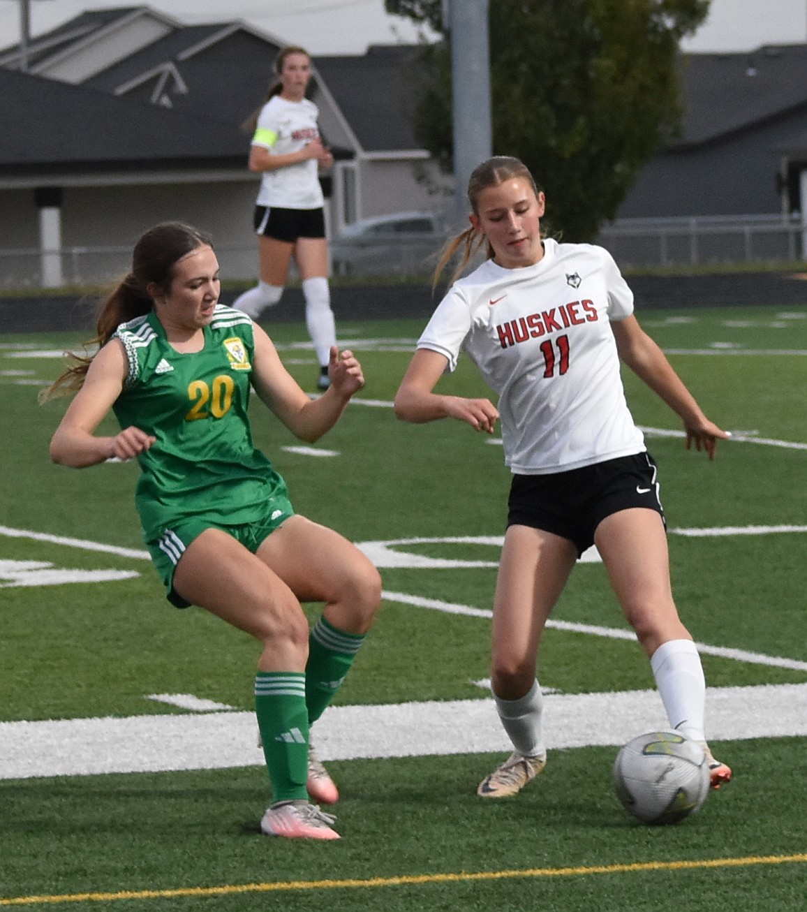 Jacks sophomore Brielle Baughman and Huskies junior Kate Mollotte compete for possession of the ball along the sideline.