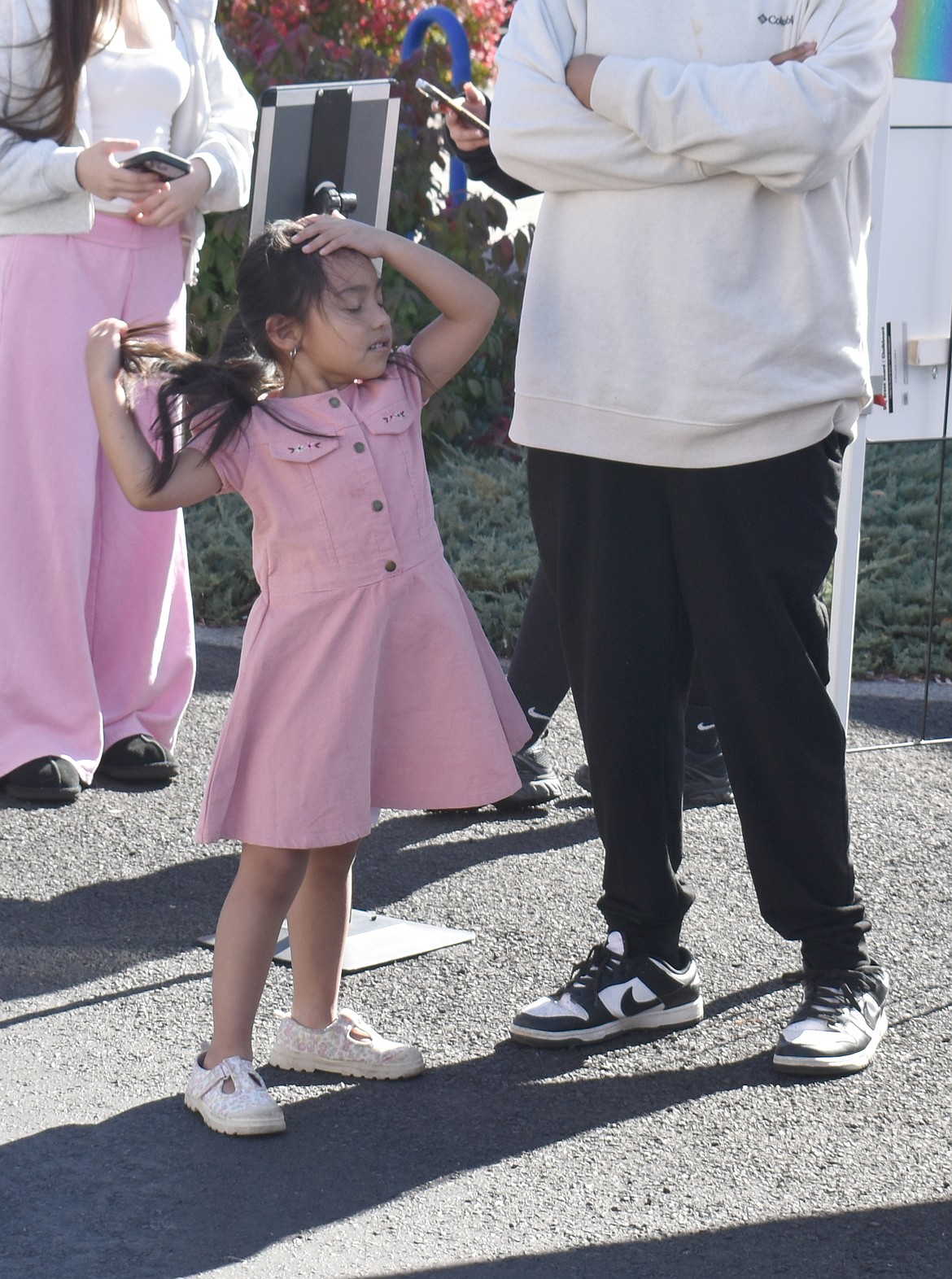 Five-year-old Elisa dances to the music while waiting in line for food at UMANI.