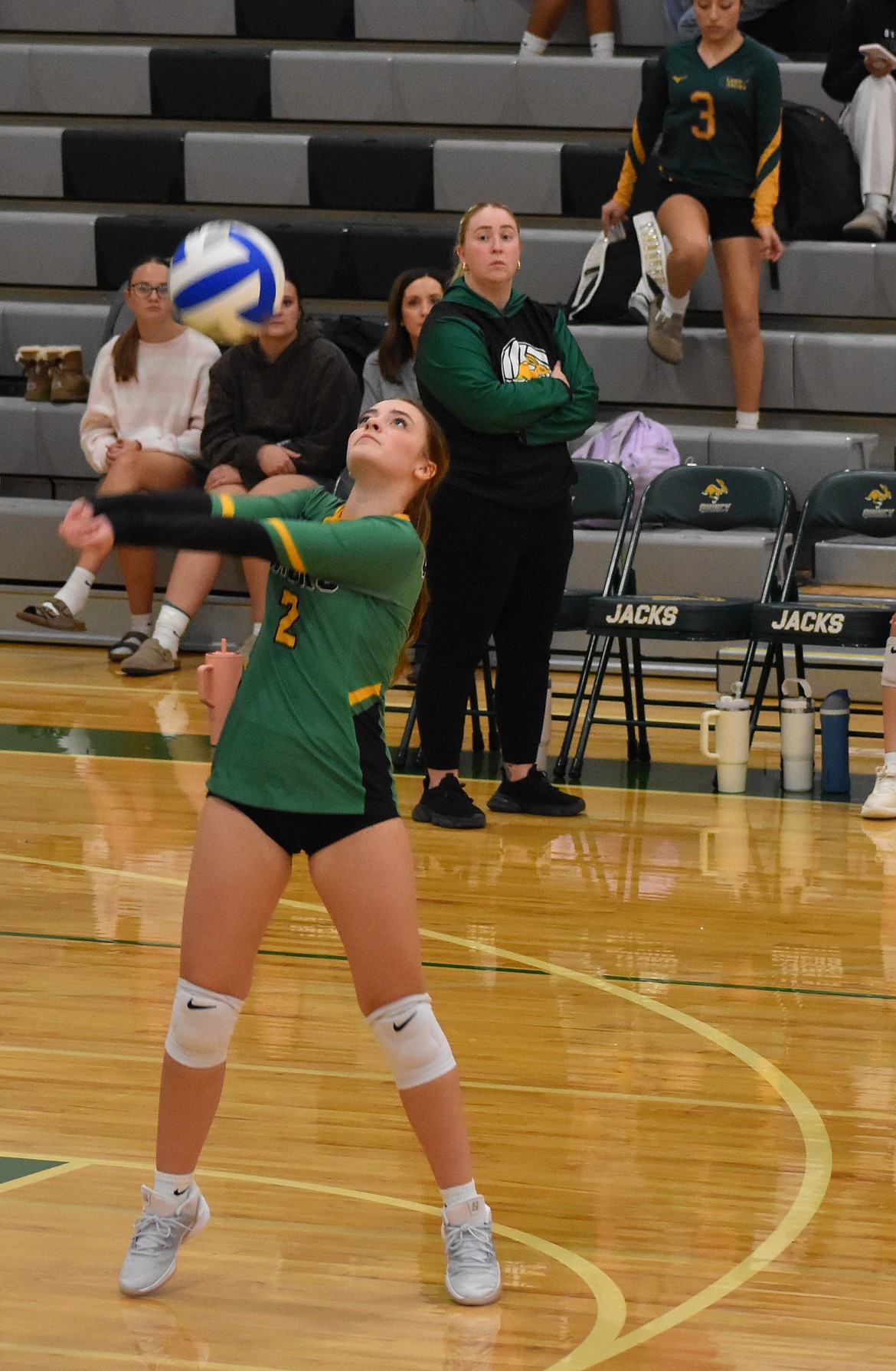 Jacks junior Karlee Weber hits the ball back over the net while head coach Chelsea Wallace watches on.